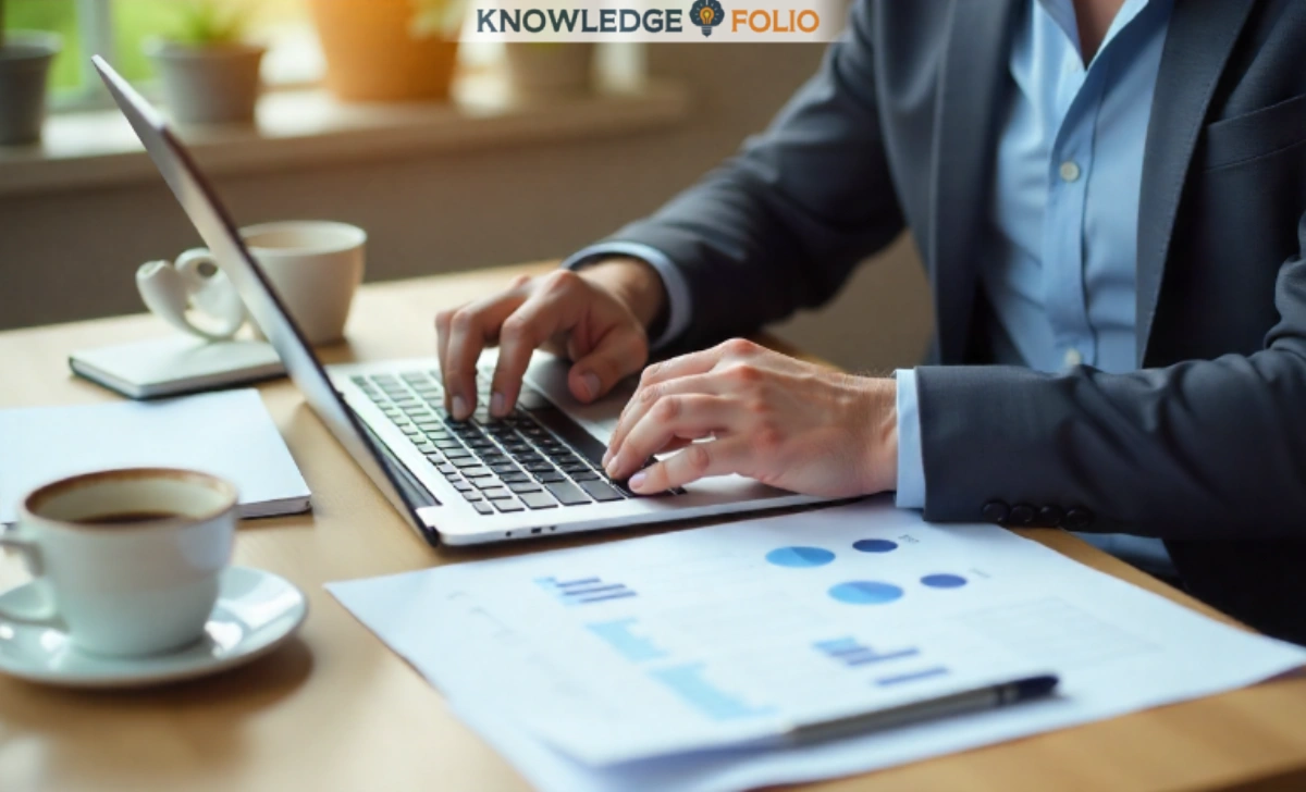 Australian entrepreneur using laptop with business planning documents, calculator, and coffee cup on desk in natural lighting.